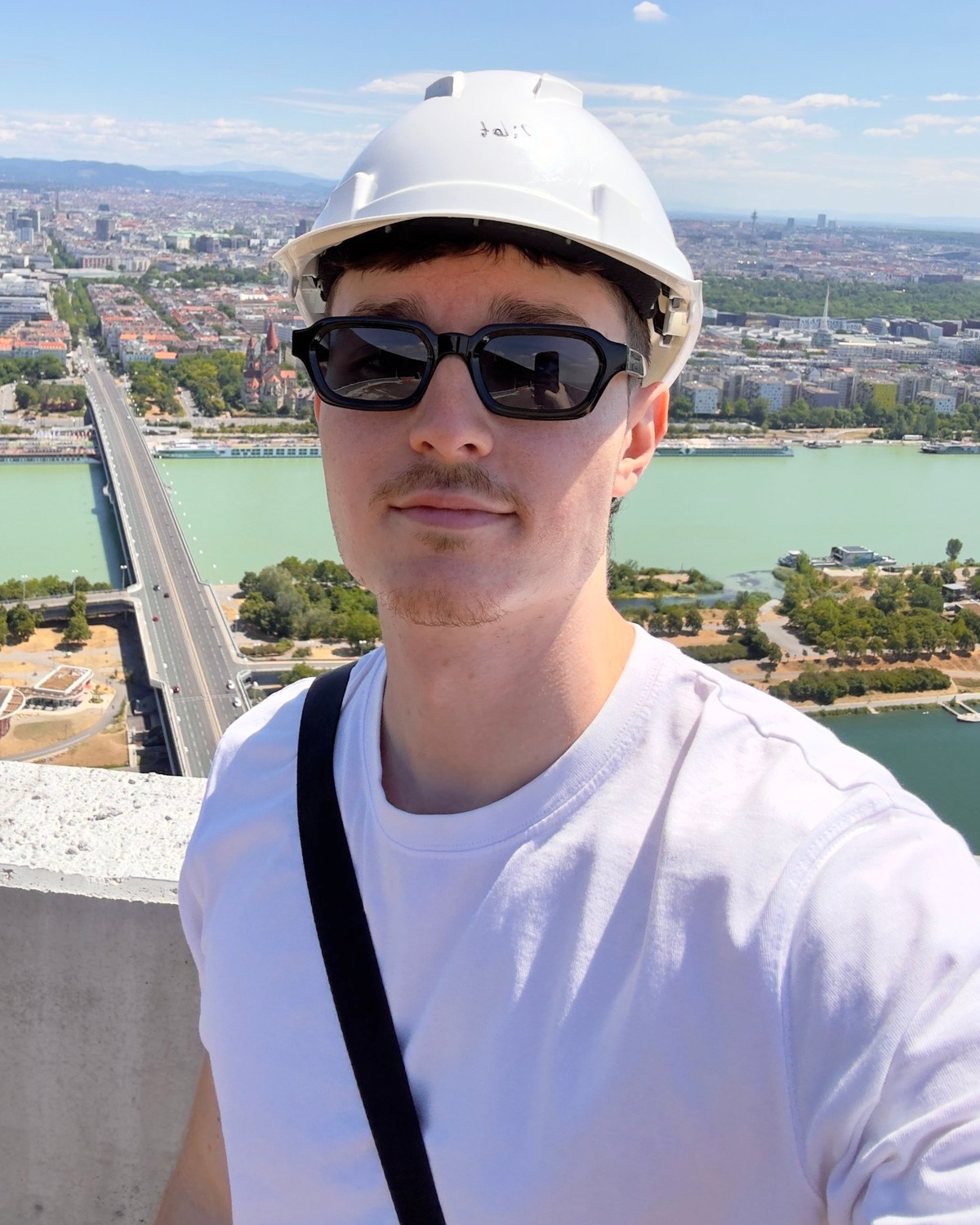 Elias Schützenhofer mit Helm hoch über der Donau in Wien